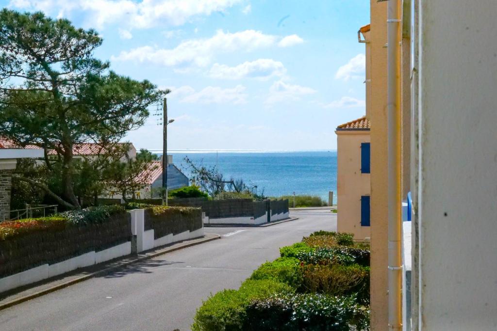 une rue vide avec un bâtiment et l'océan dans l'établissement Grand Studio proche mer quartier de la Pironnière - 4 personnes, à Les Sables-dʼOlonne