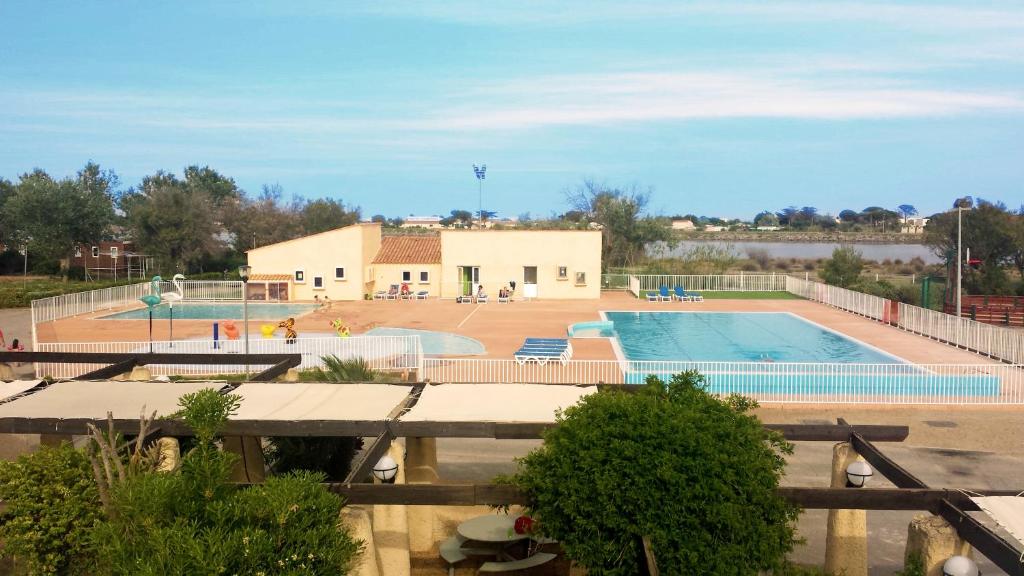 une grande piscine avec un bâtiment en arrière-plan dans l'établissement Village vacances & camping de Gruissan, à Gruissan