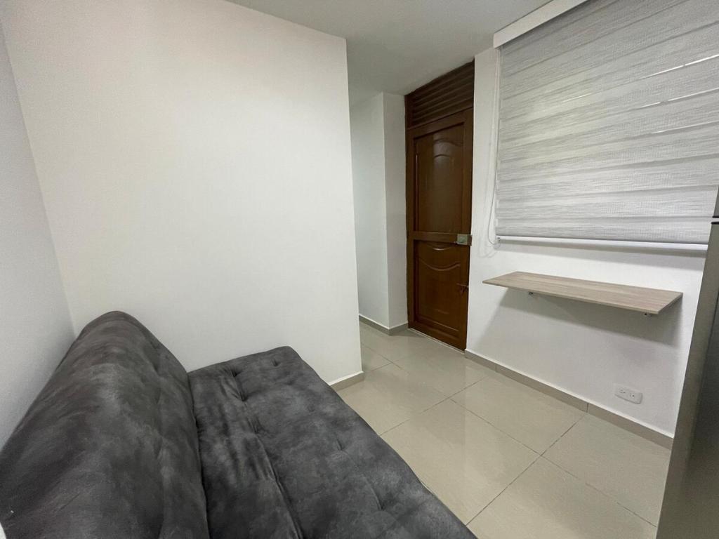 a couch in a living room with a window at Apartaloft 207 Near to hospital San Jorge in Pereira