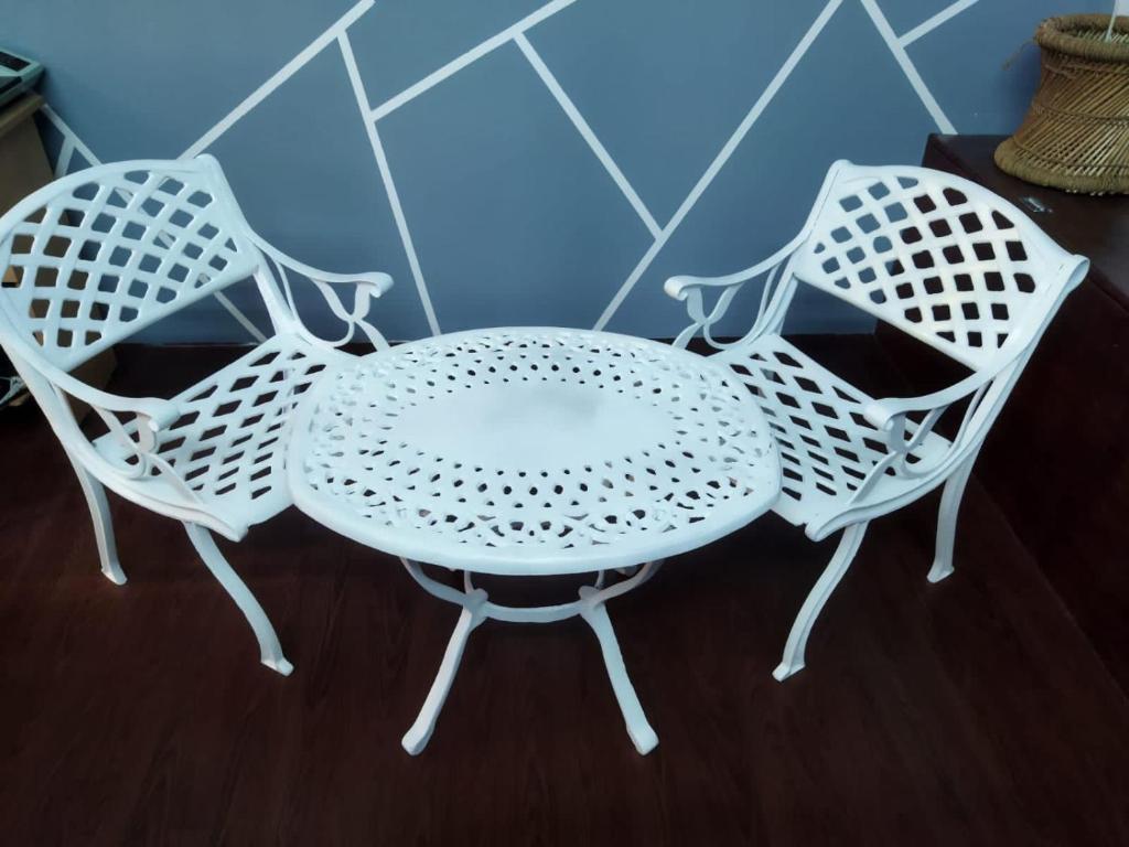 MohaliVintage homes的两把白色的椅子和一张白色的桌子和椅子