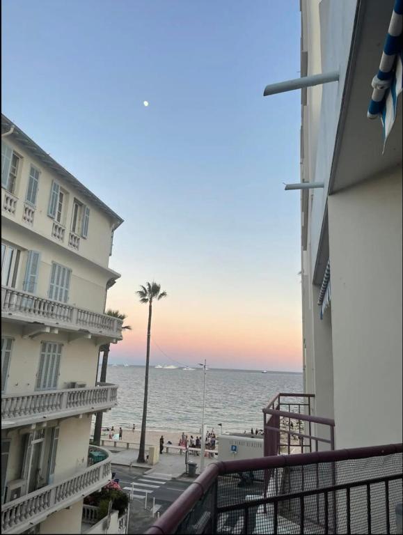 une vue sur la plage depuis le balcon d'un immeuble dans l'établissement Bright apartment - sea view, à Antibes