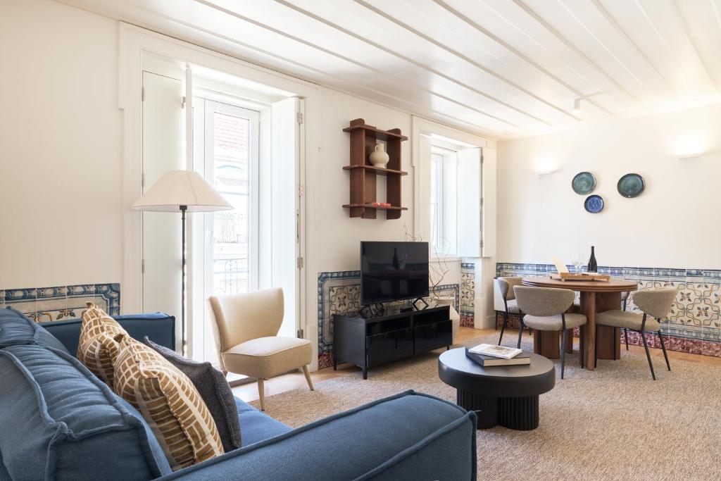 a living room with a blue couch and a table at Ando Living - Santa Justa 79 House in Lisbon