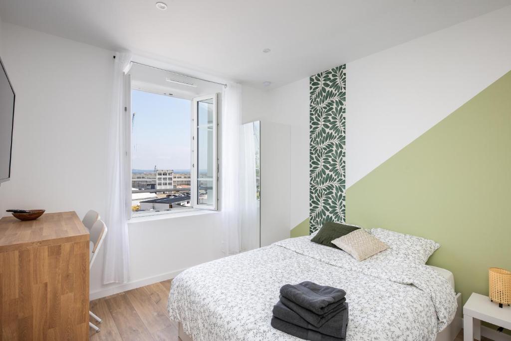 une chambre blanche avec un lit et une fenêtre dans l'établissement Pokou, à Brest