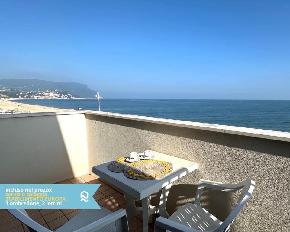 a table and chairs on a balcony overlooking the ocean at RS323 - Marcelli, bilocale fronte mare con spiaggia inclusa in Marcelli