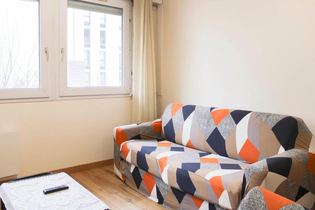 un salon avec un canapé et une fenêtre dans l'établissement Lovely 1-bedroom apartment near park, à Pantin
