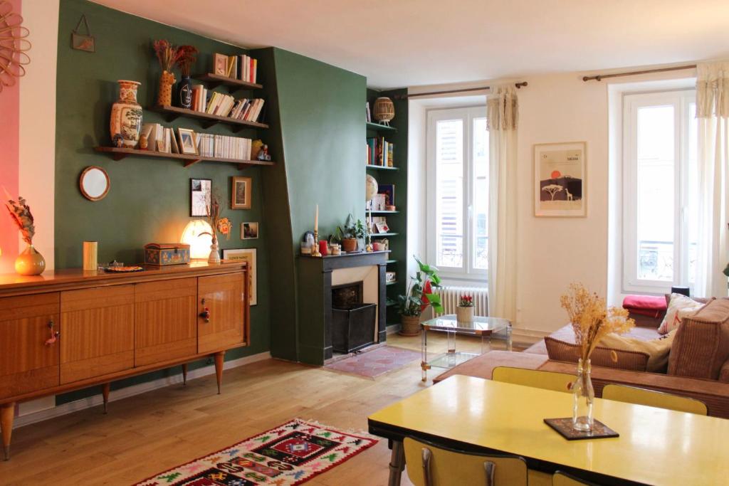 - un salon avec un mur vert et un canapé dans l'établissement Charming Parisian Stay Just Steps from Montmartre, à Paris