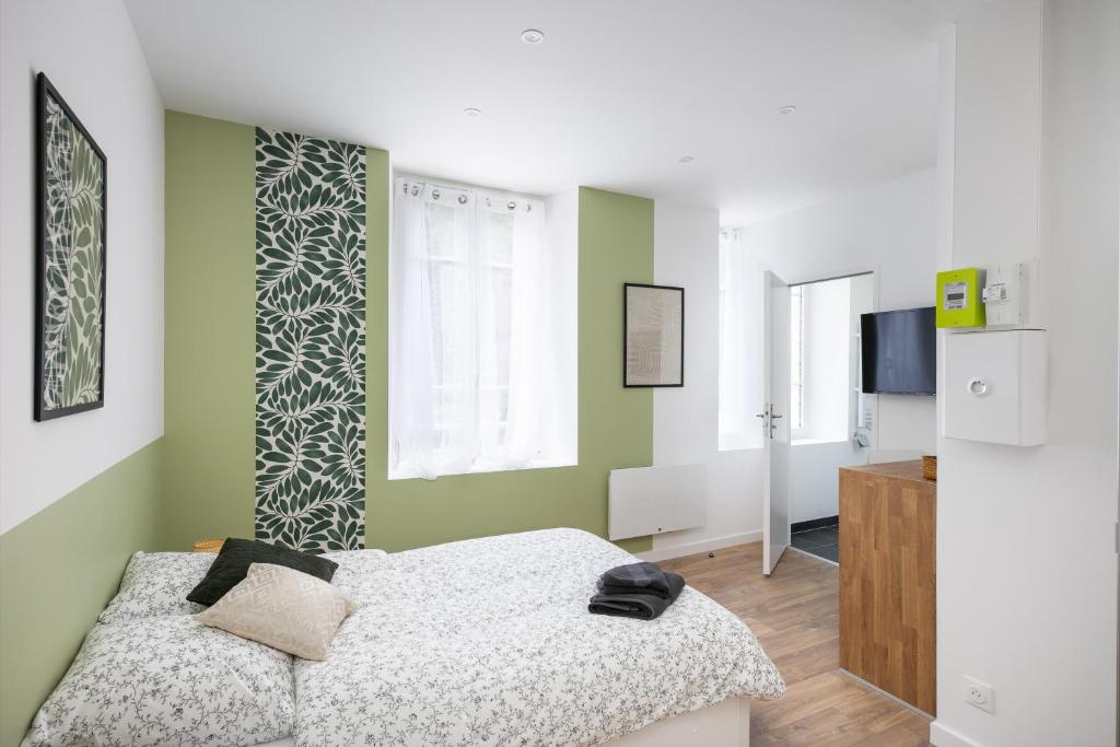 - une chambre avec des murs verts et blancs et un lit dans l'établissement Yec hed mat, à Brest