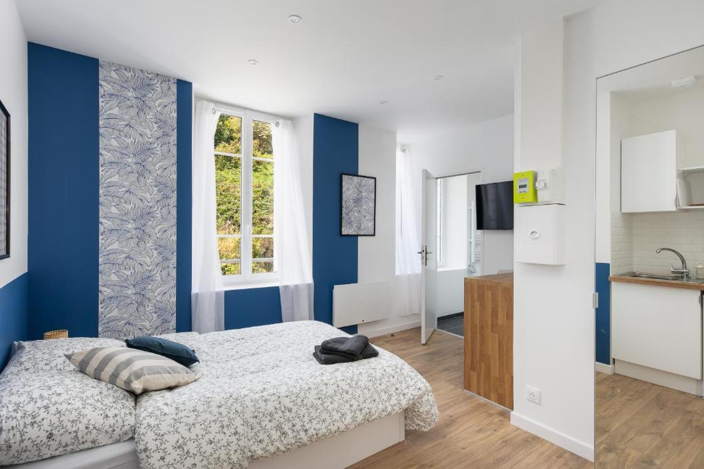 - une chambre avec des murs bleus et blancs et un lit dans l'établissement A Dreuz, à Brest