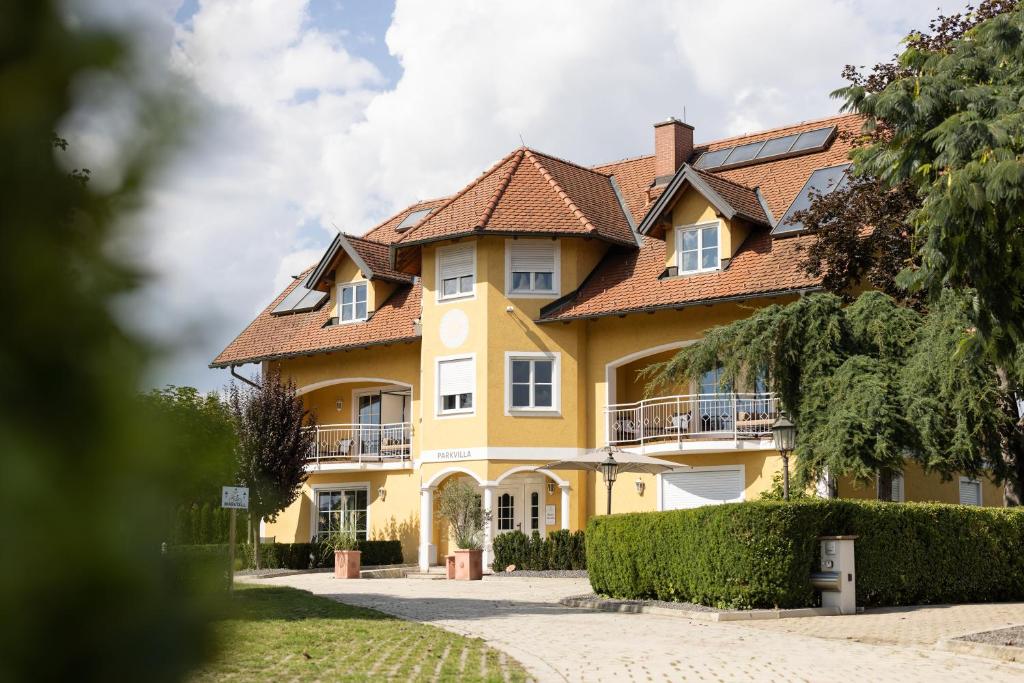 a large yellow house with a red roof at Parkvilla 11 in Fürstenfeld