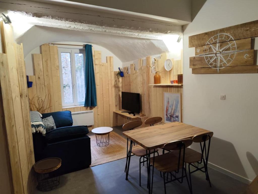 un salon avec une table et un canapé bleu dans l'établissement La Cabine du Large 2, à Montélimar