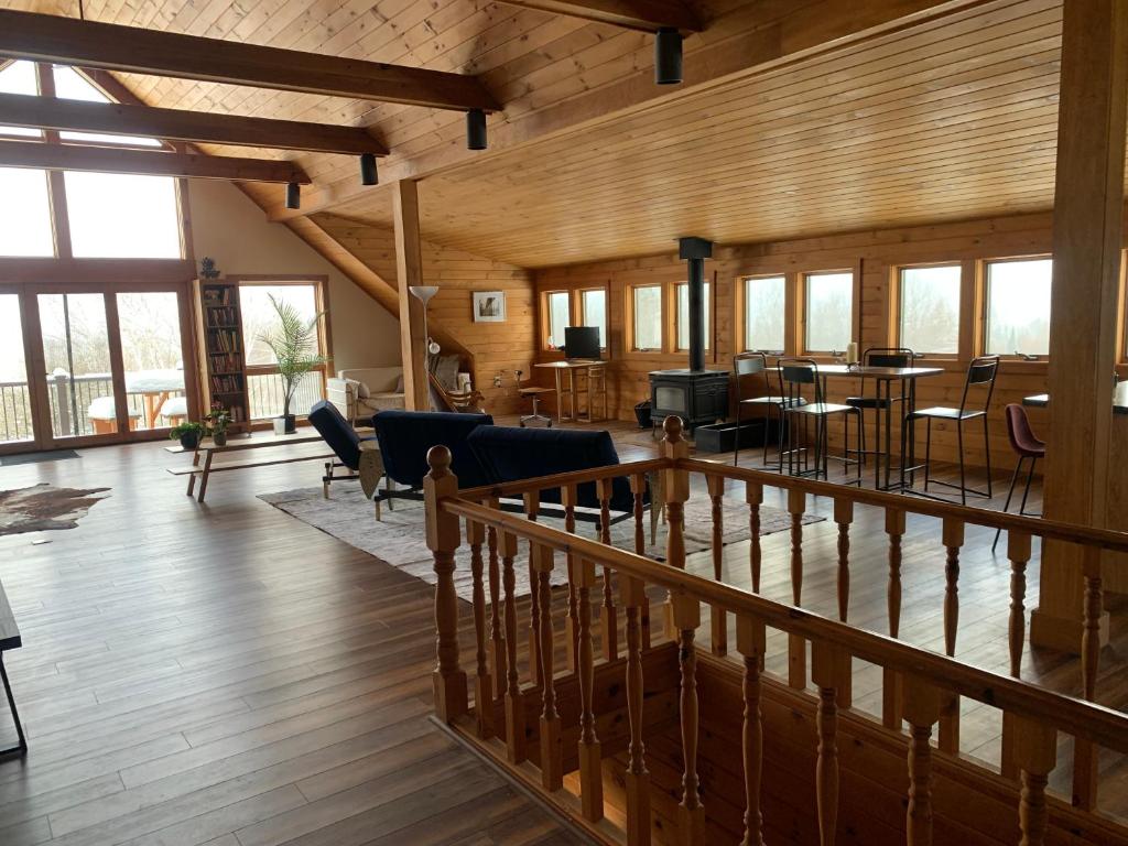 a large living room with wooden walls and windows at Charming barn loft - all amenities on 60 acre farm in the White Mountains of NH in Lancaster
