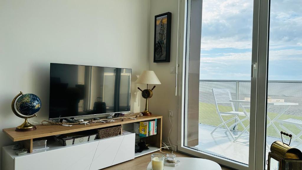 TV a/nebo společenská místnost v ubytování Face à la mer immense