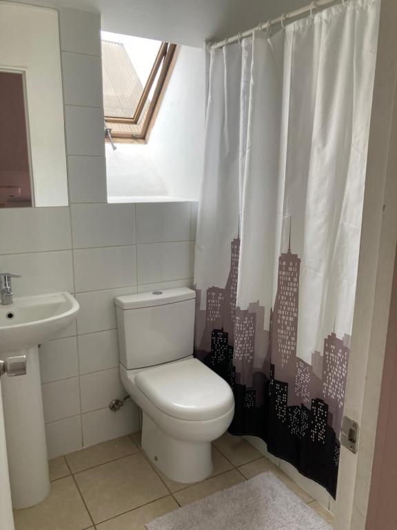 a bathroom with a toilet and a city shower curtain at Casa 4 habitaciones 2 baños in Talca