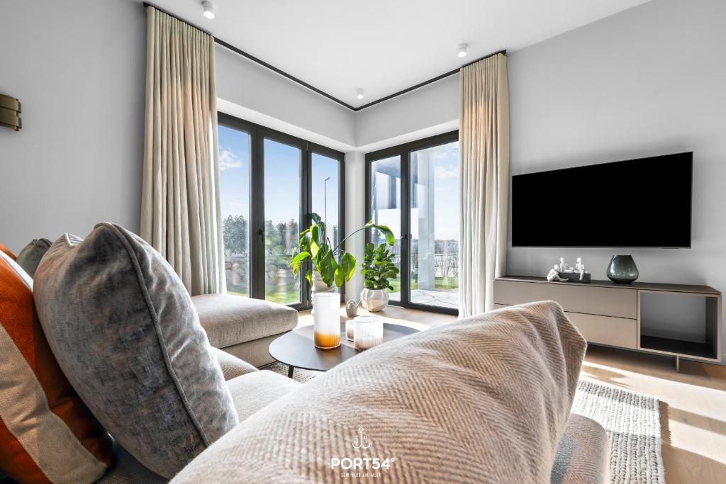 a living room with a couch and a tv at Anchorage Suite List auf Sylt in List