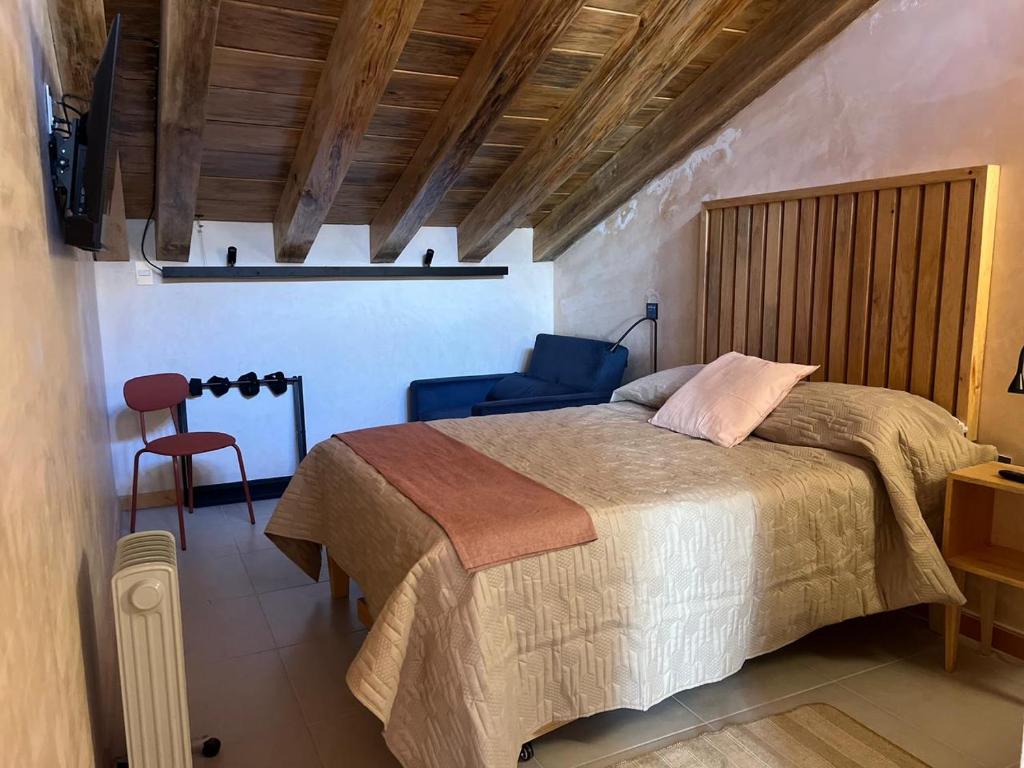ein Schlafzimmer mit einem großen Bett und einem Stuhl in der Unterkunft Casa Coco H3 Luna in San Cristóbal de las Casas