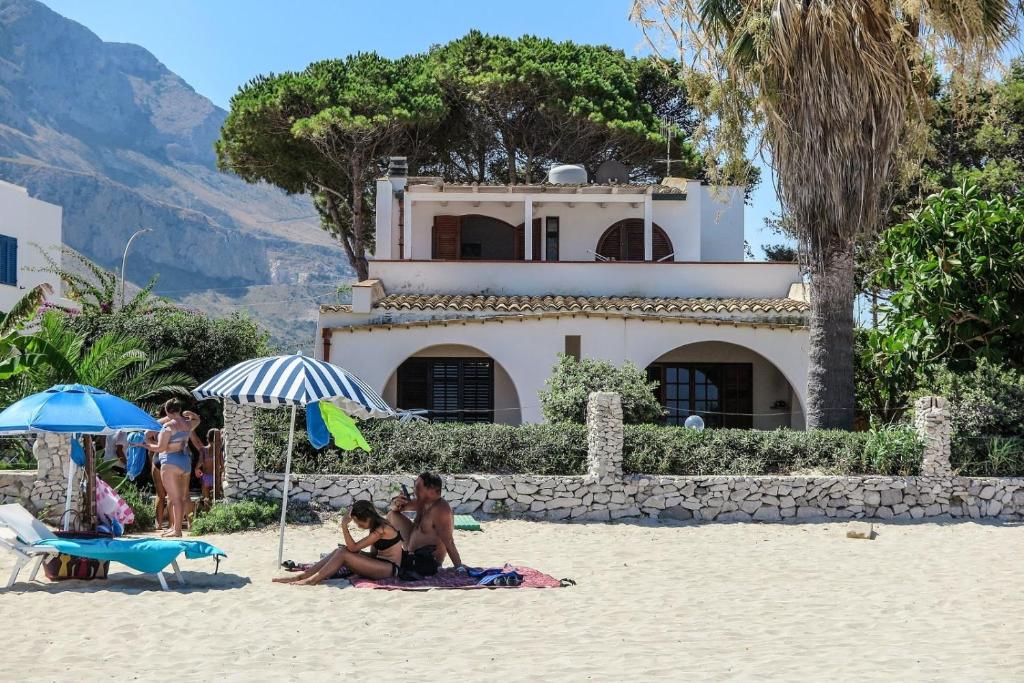 サン・ヴィート・ロ・カーポにあるVilla Hibiscoの浜辺の傘下に座る人々