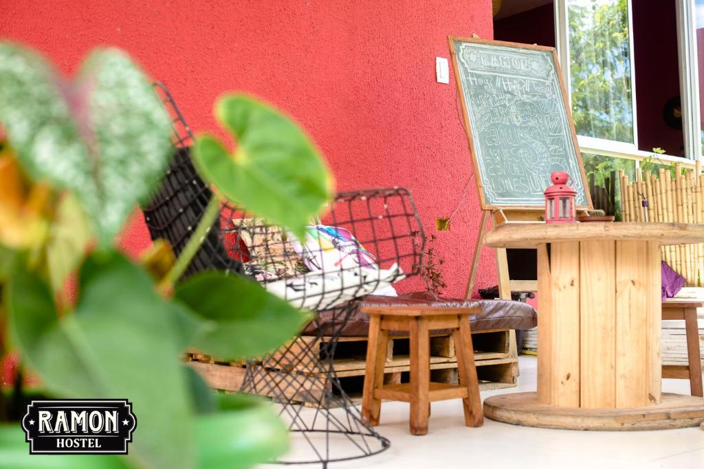 a sign and a bench in front of a red wall at Ramon Hostel Bar in Recife