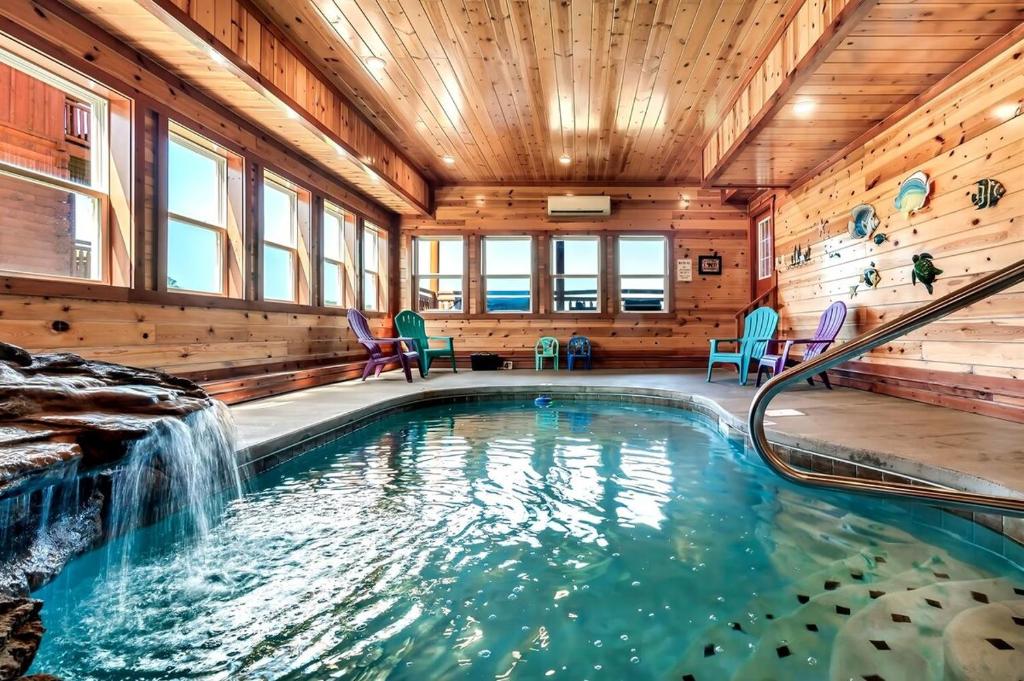 a swimming pool with a waterfall in a house at Smoky Mountain Splash in Sevierville