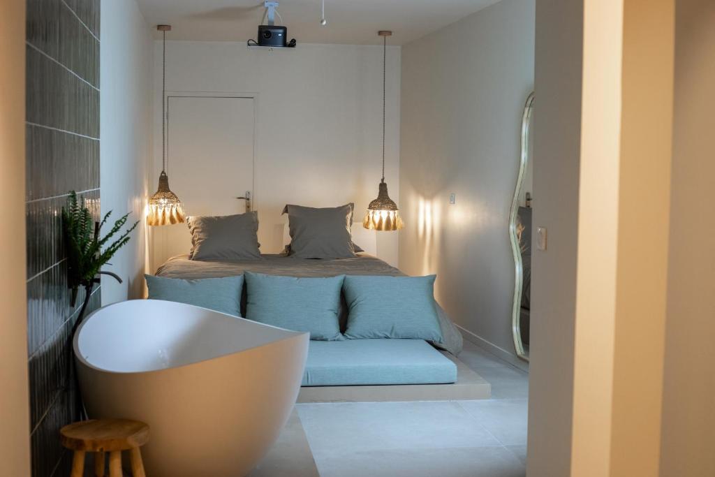 een slaapkamer met een bed en een bad. bij La Penida Suite avec Sauna & Baignoire Hyper Centre Lille in Lille