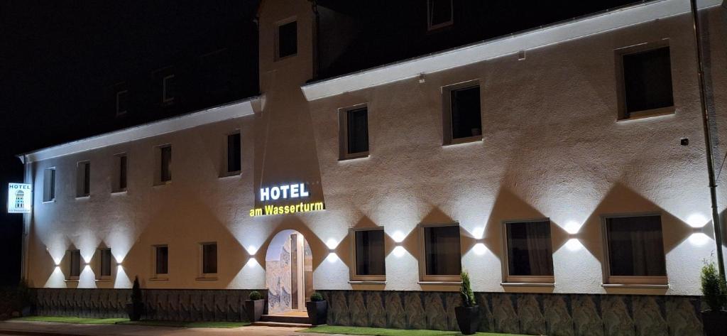 ein Gebäude mit einem Schild an der Seite nachts in der Unterkunft Hotel am Wasserturm in Crailsheim
