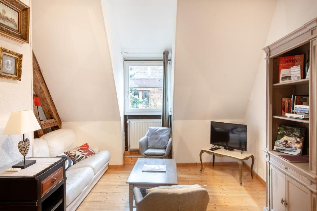 a living room with a couch and a tv at L'Atypique au coeur du Vignoble in Hunawihr