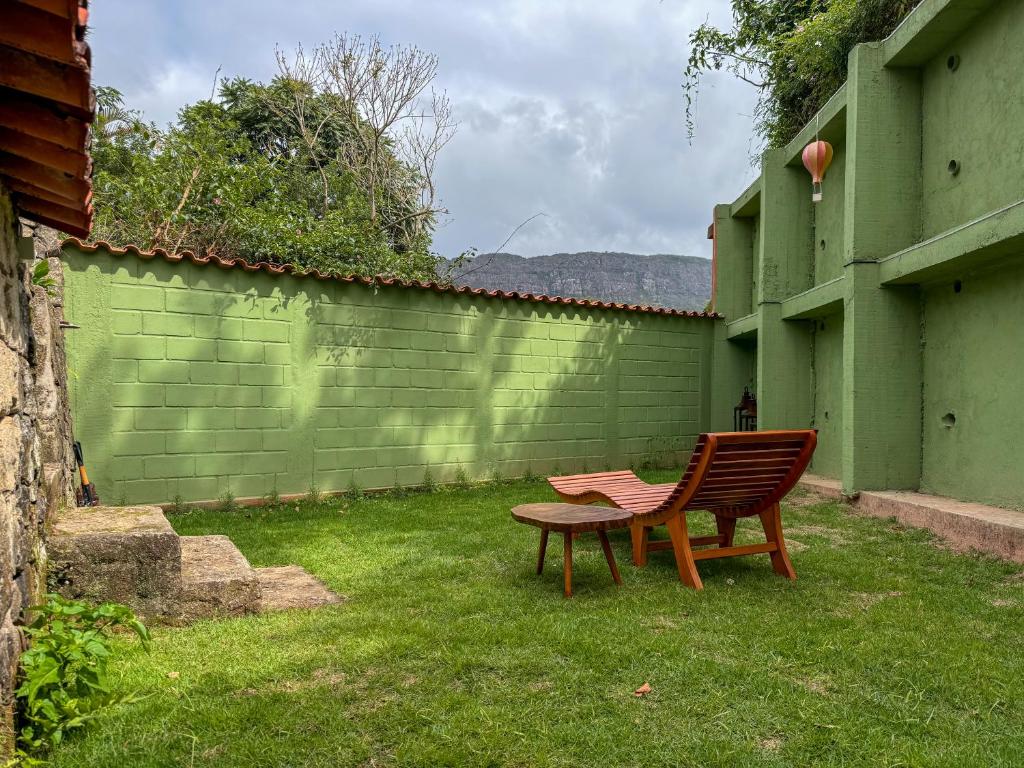 a chair and a table in a yard with a fence at Jardim da Música Tiradentes in Tiradentes