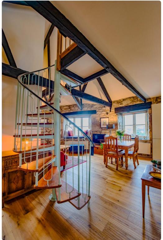 a spiral staircase in a living room with a table at The Wheel House in Penzance