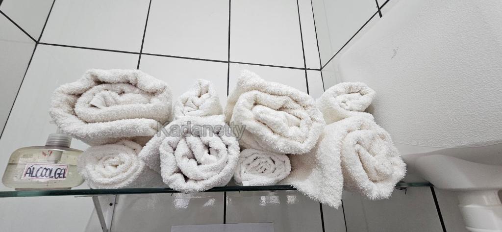 een stapel handdoeken op een plank in een badkamer bij Casa Ventilada e Confortável, Perto da Rodovia e 2km da Praia in Caraguatatuba