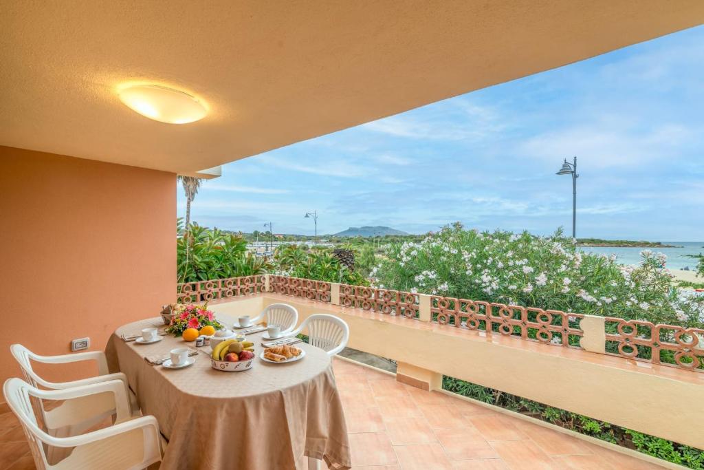 a table and chairs on a balcony with a view of the ocean at House Bados beach in Olbia