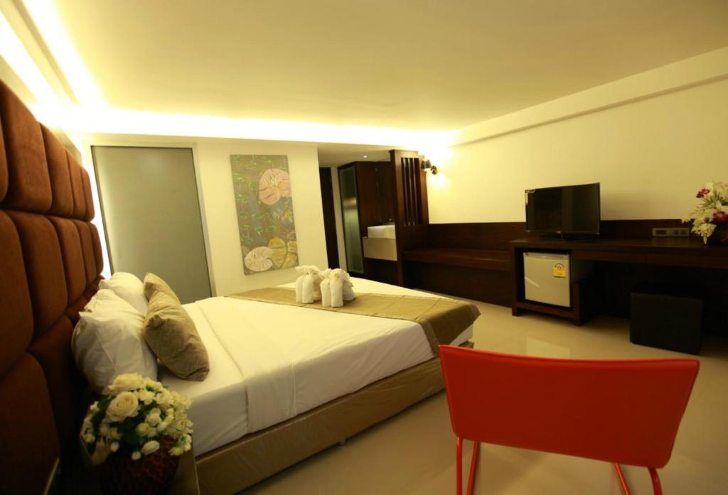 a hotel room with a bed and a television at The Bangkok Major Suite in Bangkok