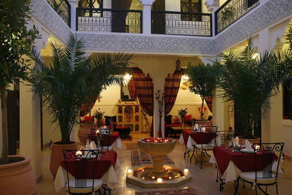 a restaurant with tables and chairs and a fountain at Riad Shaloma in Marrakesh