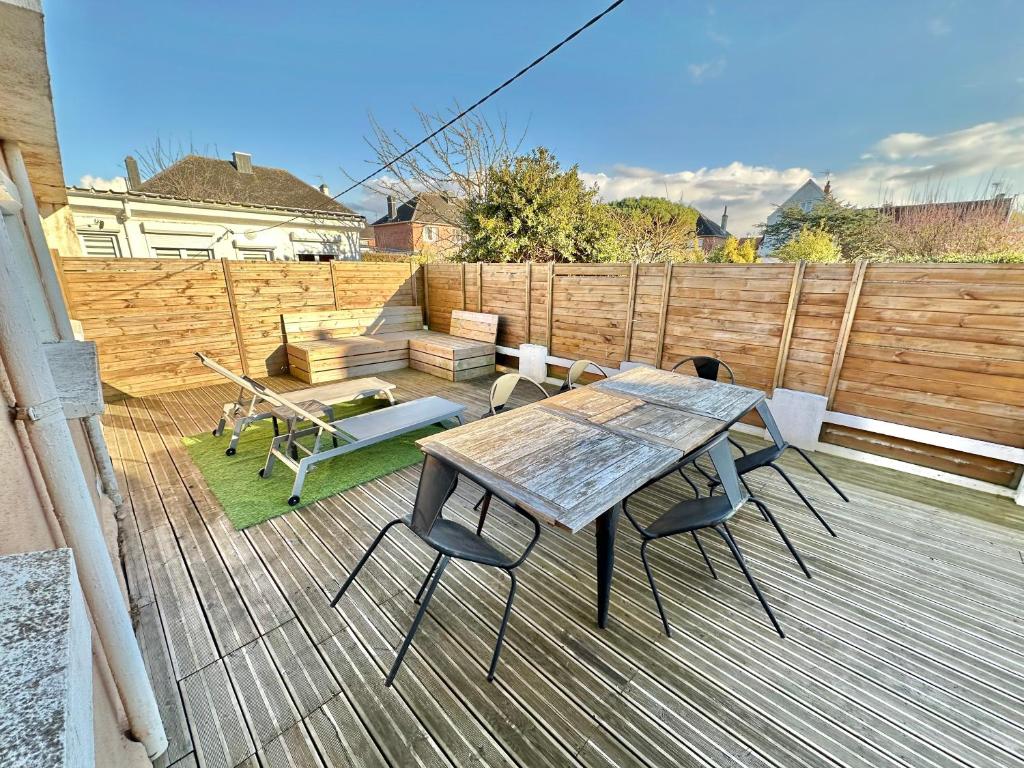 a wooden table and chairs on a deck at Petite maison de vacances - Terrasse - Berck-Plage in Berck-sur-Mer