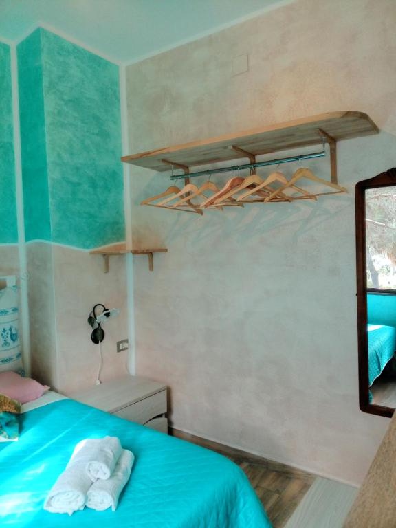 ein Schlafzimmer mit einem blauen Bett mit Handtüchern darauf in der Unterkunft Pinus Village, Pula, sud Sardegna casa vacanze Vera's House in Fort Village