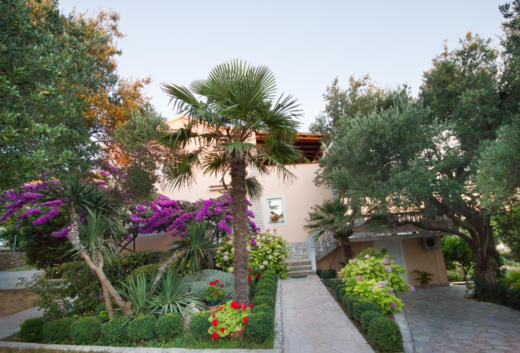 a house with trees and flowers in front of it at Apartments Pende in Rab