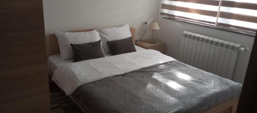 a bed in a small room with a window at Ruža vetrova A3 dupleks in Nova Varoš