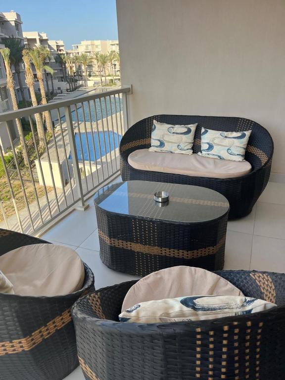 a balcony with couches and a table with a dog laying on it at Chalet in marassi marina pool view exm80 in El Alamein