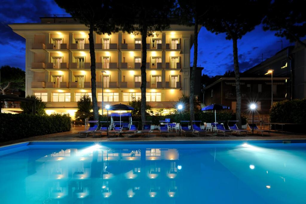 a hotel with a swimming pool at night at Hotel Tiffany in Rimini