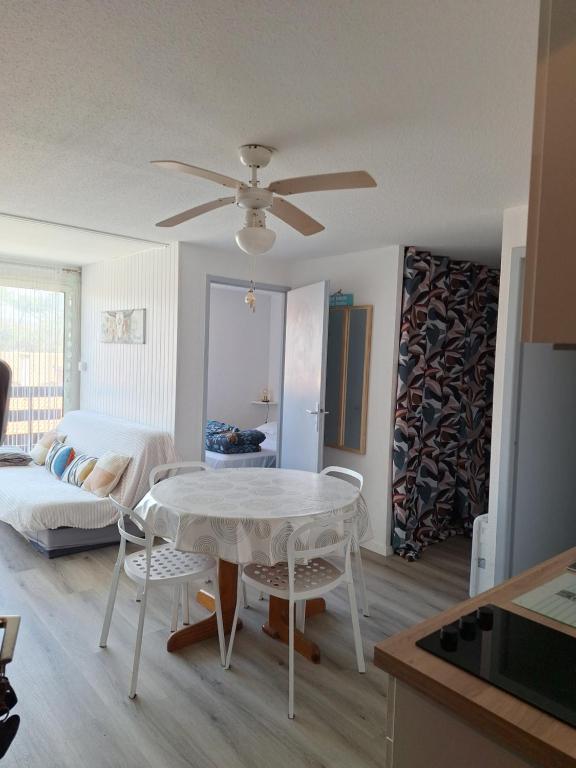 eine Küche und ein Wohnzimmer mit einem weißen Tisch und Stühlen in der Unterkunft appartement T2bis idealement situé au bord du lac marin de Vieux Boucau in Vieux-Boucau-les-Bains