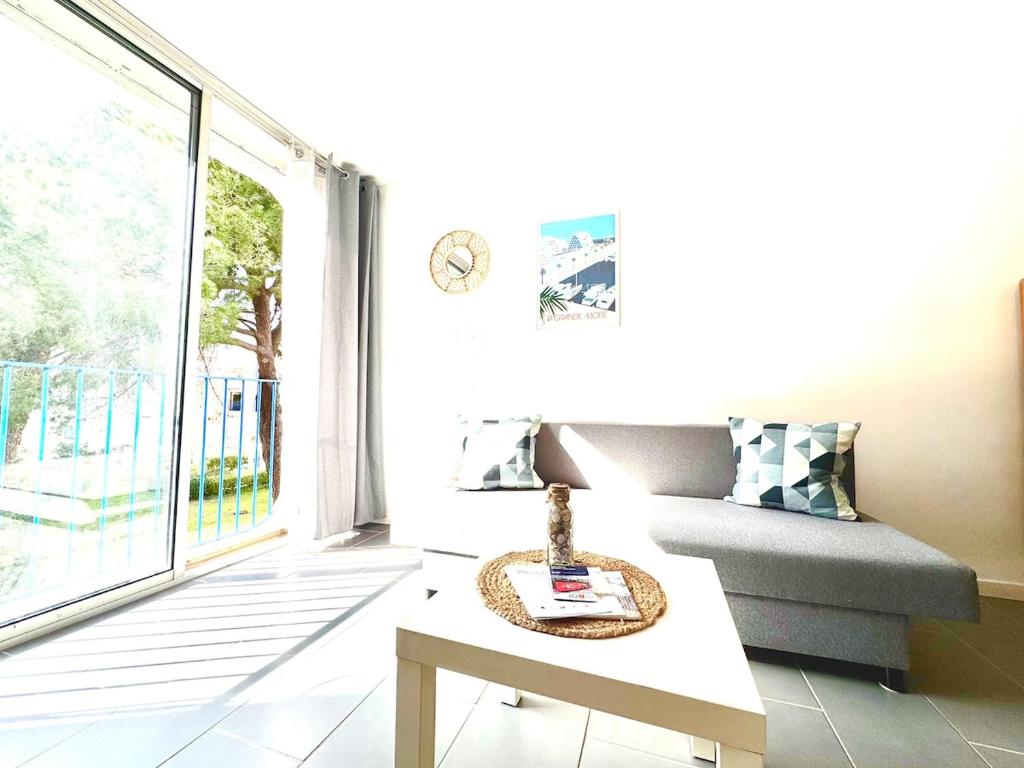 un salon avec un canapé et une table dans l'établissement Entre Étang et Mer - Parking - Cadre Verdoyant, à La Grande Motte