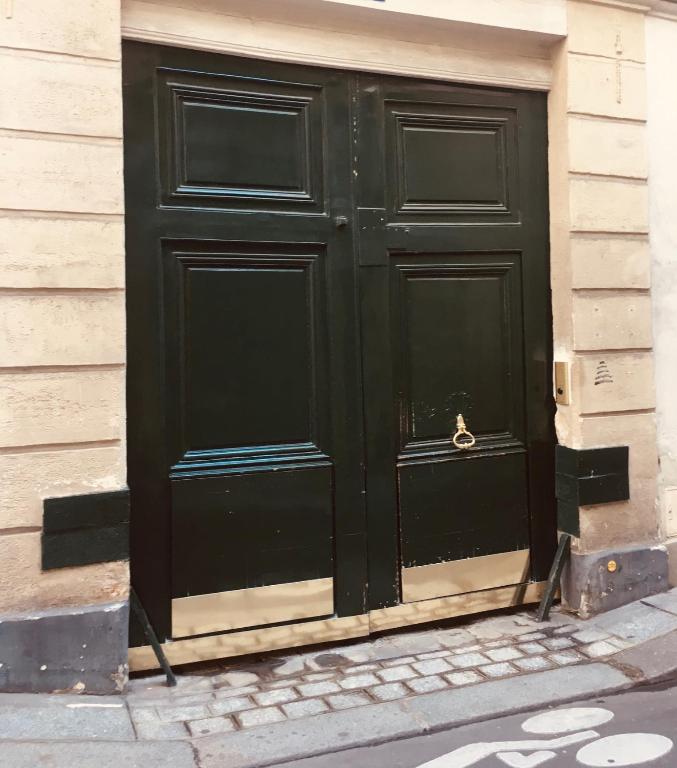 une porte noire sur le côté d'un bâtiment dans l'établissement Petit PARIS, à Paris