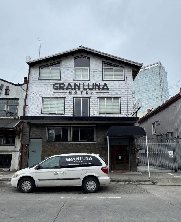 a white car parked in front of a building at Hotel Gran Luna in Puerto Montt