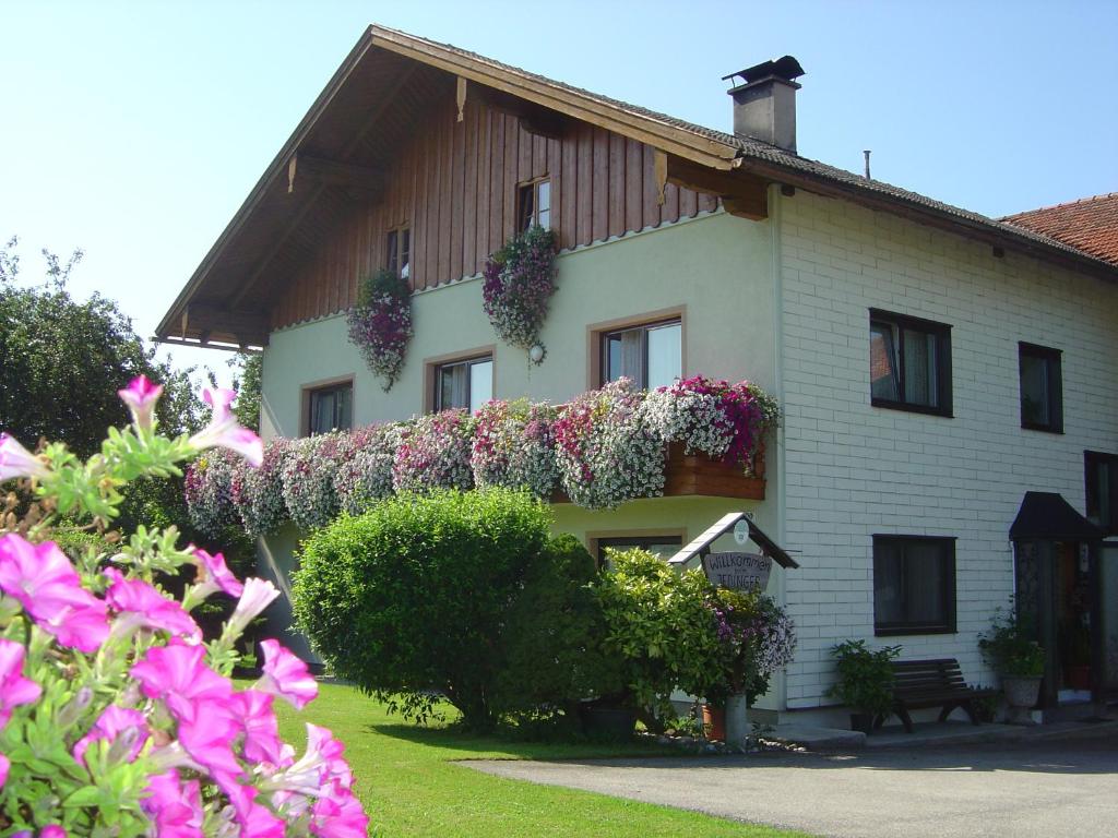 una casa con flores a un lado. en Gästehaus Jedinger, en Oberhofen am Irrsee