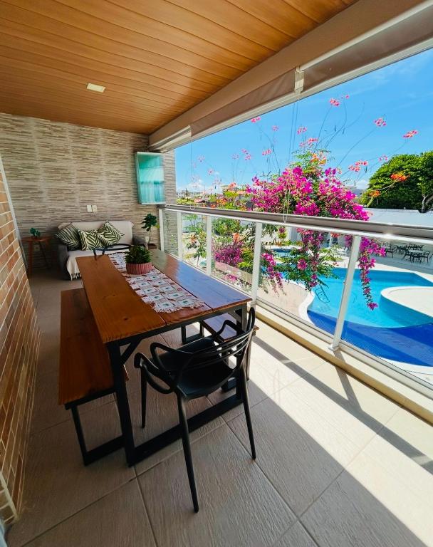 a balcony with a table and a view of a pool at Apartamento em Praia do Francês in Praia do Frances