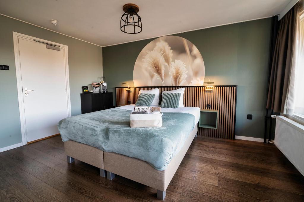 a bedroom with a bed with a large painting on the wall at Hotel het Rietershuijs in Kalenberg