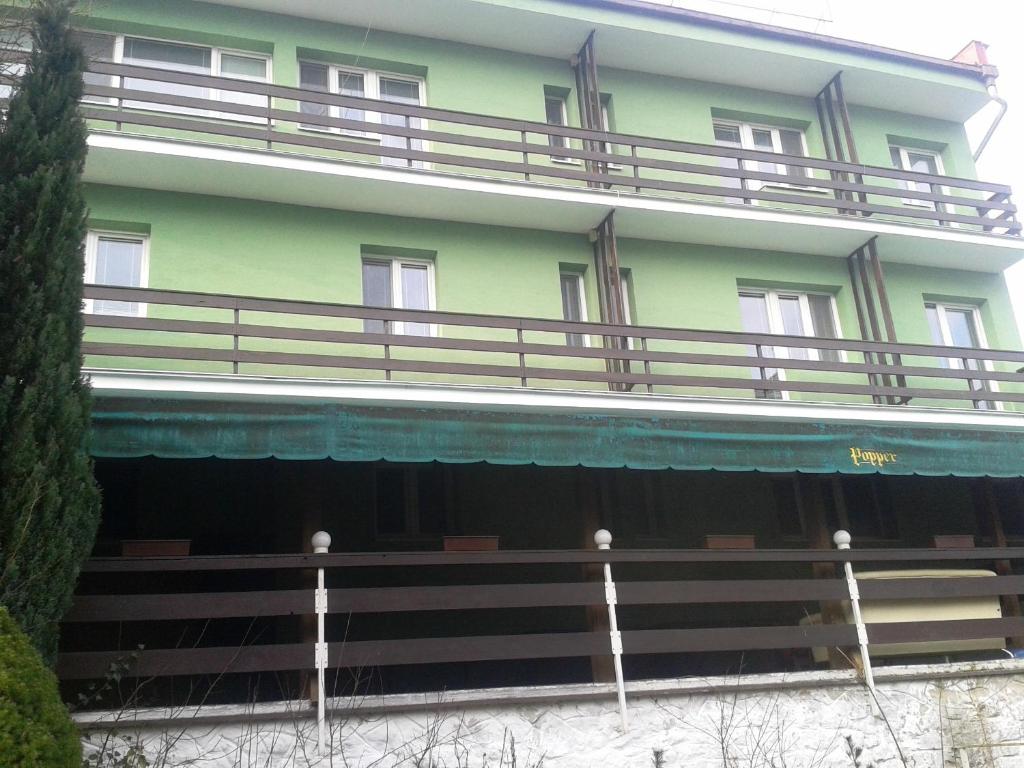 un gran edificio verde con balcones en la parte superior. en Garni Hotel Sonata en Trenčianske Teplice