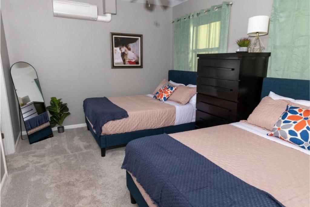 a small bedroom with two beds and a dresser at Little Rock - Cozy Downtown Retreat in Little Rock