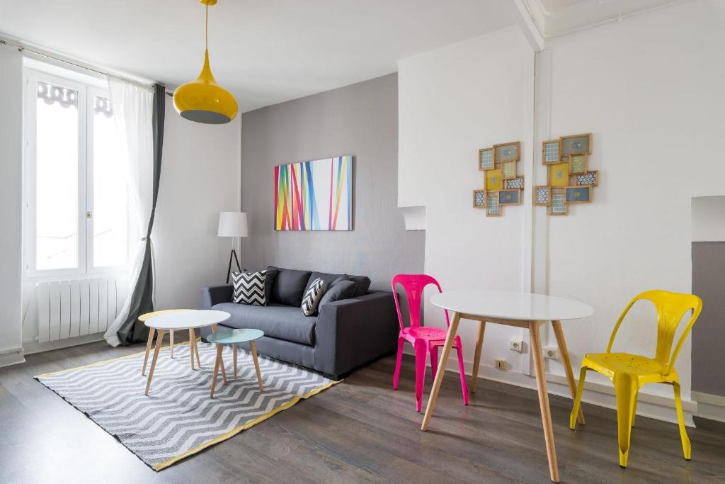un salon avec des chaises colorées et un canapé dans l'établissement Appartement Lyon Villeurbanne - Enjoy in Lyon, à Villeurbanne