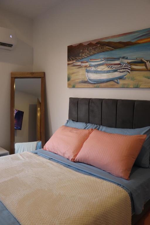 ein Schlafzimmer mit einem Bett und einem Gemälde an der Wand in der Unterkunft apartamento con vista al mar in Santa Marta