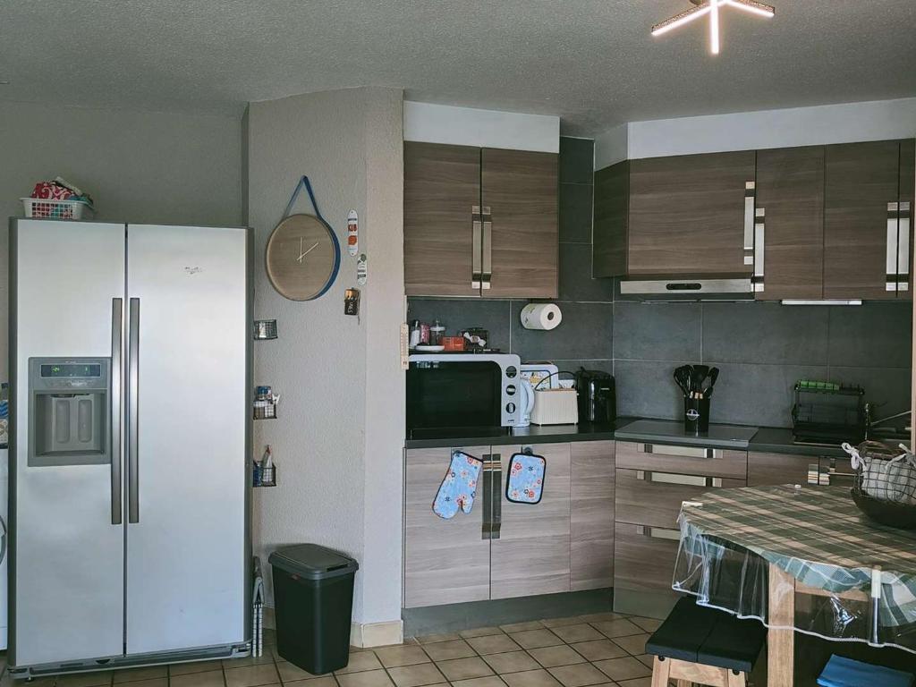 une cuisine avec un réfrigérateur et une table à l'intérieur dans l'établissement T2 Cabine climatisé avec WiFi au Barcarès - FR-1-195-114, au Barcarès