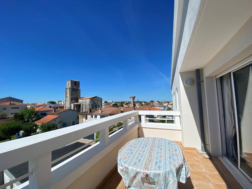 d'un balcon avec une table et une vue sur la ville. dans l'établissement Royan : Appartement 47m², Balcon, Parking privé, Ascenseur - FR-1-738-48, à Royan